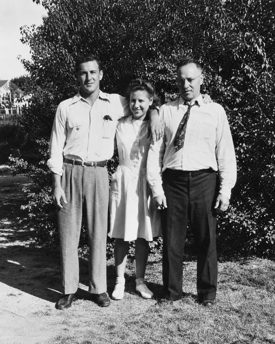 Black-and-white photograph, from left: Lucian, Wanda and their father, Teofil, standing on a lawn.